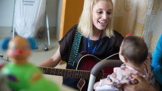 University of the Pacific MA in Music Therapy student Kathleen Humphries works with young patient during field visit.